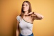 © Krakenimages.com - Young beautiful redhead woman wearing casual t-shirt over isolated yellow background cutting throat with hand as knife, threaten aggression with furious violence