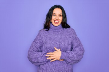 Wall Mural - Young beautiful woman wearing casual turtleneck sweater standing over purple background smiling and laughing hard out loud because funny crazy joke with hands on body.