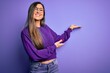 © Krakenimages.com - Young beautiful smart woman wearing glasses over purple isolated background Inviting to enter smiling natural with open hand