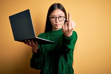 Poster - Young asian business woman wearing glasses and working using computer laptop Showing middle finger, impolite and rude fuck off expression