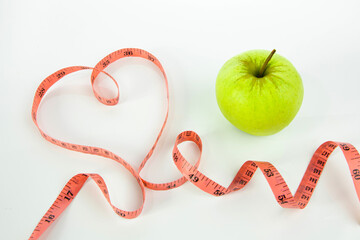 Heart shaped green apple with tape measure.