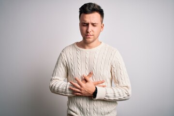 Young handsome caucasian man wearing casual winter sweater over white isolated background with hand on stomach because indigestion, painful illness feeling unwell. Ache concept.