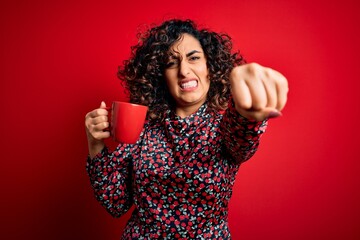 Sticker - Young beautiful curly arab woman drinking mug of coffee over isolated red background annoyed and frustrated shouting with anger, crazy and yelling with raised hand, anger concept