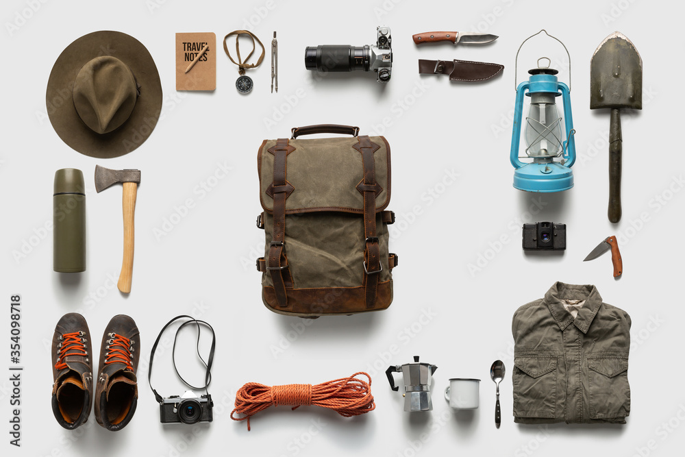 Packing backpack for a trip concept with traveler items isolated on white background - obrazy, fototapety, plakaty 