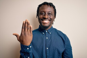 Sticker - Young african american man showing golden marriage ring on finger over white background with a happy face standing and smiling with a confident smile showing teeth