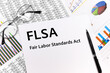 © Krystsina - text FLSA fair labor standards act written on the sheet. pen, glasses, documents, graphics.