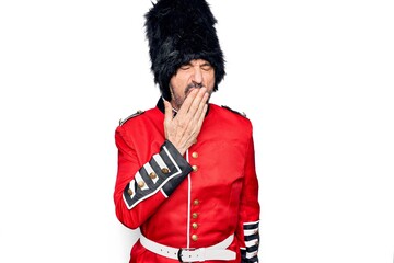 Sticker - Middle age handsome wales guard man wearing traditional uniform over white background bored yawning tired covering mouth with hand. Restless and sleepiness.