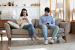© fizkes - Millennial man and woman sit separately on couch in living room using smartphones not talking, young caucasian couple addicted to cellphones, browse gadgets, technology, device addiction concept