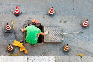 sequence of worker going in the manhole in the street, step 2