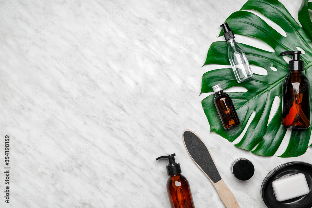 Shower gels with bath supplies on light background