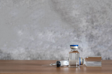 Wall Mural - Close up accessories healthcare & medical with coronavirus background concept.Anti retroviral vaccine bottle with Syringe on grey cement.On the  table items for doctor using treat patient Covid-19.