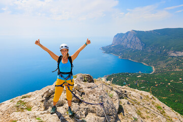 Wall Mural - Happy young woman stand on mount top. Amazing sea landscape. Family travel adventure, hiking activity. Via ferrata tour with kids, exploring nature on summer vacation. Weekend day walking tour