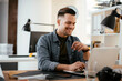 © JustLife - Young businessman using laptop in his office.  Handsome man working in office.
