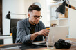 © JustLife - Young businessman using laptop in his office.  Handsome man working in office.