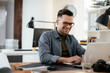 © JustLife - Young businessman using laptop in his office.  Handsome man working in office.