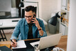 © JustLife - Businessman in office. Handsome man talking on phone at work.