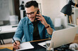 © JustLife - Businessman in office. Handsome man talking on phone at work.
