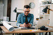 © JustLife - Portrait of handsome businessman. Man using phone.