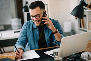 businessman in office. handsome man talking on phone at work.