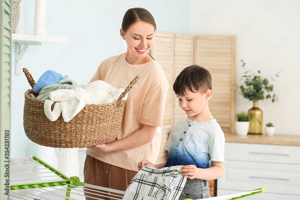Young woman with her little son doing laundry at home