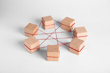 Wooden Cubes Tied With Red Thread On Light Background. Unity Concept