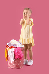 Wall Mural - Little girl with dirty laundry on color background