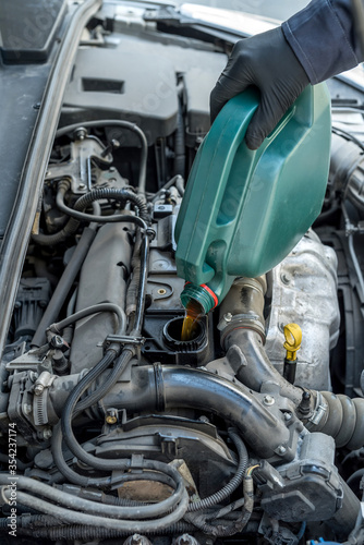 Fotografía mechanic pouring oil to car engine. auto motor service.