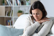 © PheelingsMedia - Sad pensive middle age woman looking down sitting at home
