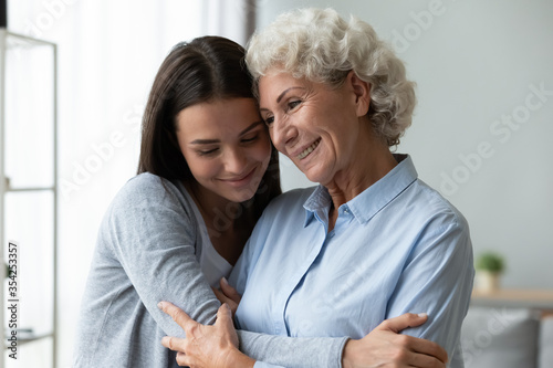 Cuadros en Lienzo Young granddaughter snuggle to elderly grandmother, different generations women