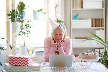 Wall Mural - Senior woman with laptop indoors at home, celebrating distance birthday.