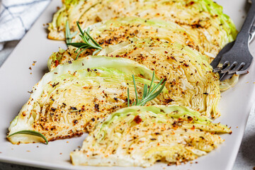 Wall Mural - Baked cabbage steaks with spices on gray plate. Healthy vegan food concept.