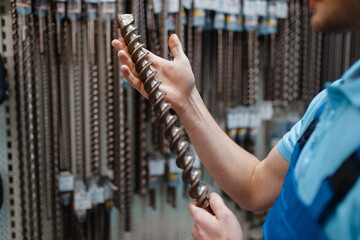 Wall Mural - Employee choosing concrete drill in tool store