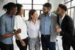 © fizkes - Happy diverse employees team celebrating success, business achievement hugging with smiling businesswoman team leader, standing in modern office, engaged in team building activity at meeting