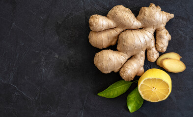 Wall Mural - Ginger root  with yellow lemone and green leafs on dark background, copy space, copyspace, top view