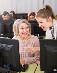 Wall Mural - Female teacher helping smiling mature woman