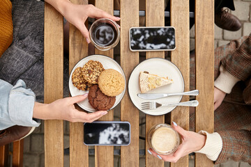 Wall Mural - sweet dessert with a cup of coffee and female hands with a phone