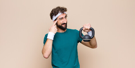 Wall Mural - young cool bearded man at gym with a dumbbell. sport concept