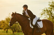 Girl equestrian rider riding a beautiful horse  in the rays of the setting sun. Horse theme 