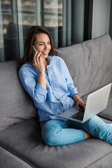 Sticker - Image of woman talking on mobile phone and using laptop while sitting