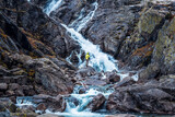 Waterfall in Tatra Mountains. Tourist standing in front of Siklawa Waterfall. Beautifull outdoor photography.