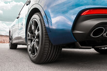 Car On Sky Background. Car Wheels Close Up On A Background Of Asphalt. Car Tires. Car Wheel Close-up. For Advertising