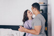 © LIGHTFIELD STUDIOS - happy interracial couple dancing and looking at each other in bedroom