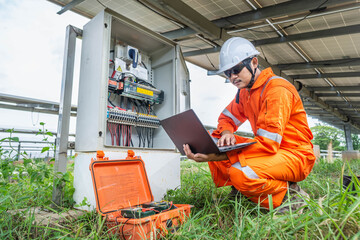 Engineers upload data of power energy to a laptop for checking the performance of the solar panel to confirming systems working normally. Concepts professional engineer for the Solar cell power plant