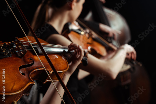 Obrazy filharmonia  przyciety-widok-profesjonalnych-muzykow-grajacych-na-skrzypcach-na-ciemnej-scenie-selektywne