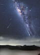 Deszcz meteorów nocnym gwiezdzistym niebie w Indonezji. Wulkan Bromo i Droga Mleczna w bezksiężycową noc