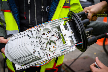 man holding the internal plate of a fiber optical splice closure with splice trays visible