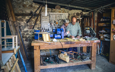 Wall Mural - Senior couple working in a carpentry workshop