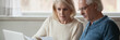 © fizkes - 60s spouses serious couple read financial statement papers analyzing family expenses feels concerned. Bank debt, overspend, finance problems concept. Horizontal photo banner for website header design