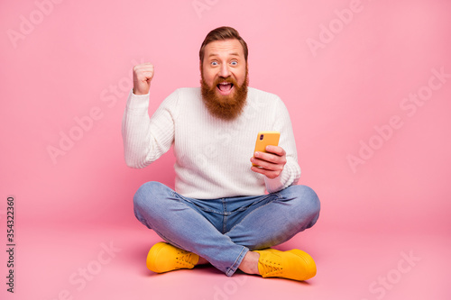 Fotografía Ful length photo delighted guy sit floor legs crossed use smartphone blogging wi