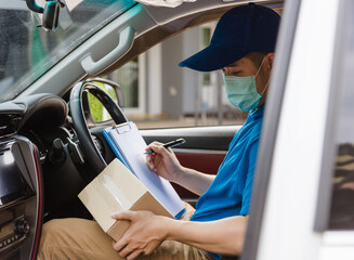 Wall Mural - Asian delivery courier young man driver inside the van car with parcel post boxes checking amount he protective face mask, under curfew quarantine pandemic coronavirus COVID-19